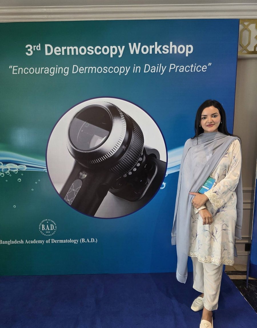 Dr. Tasmin Tahnin Siha standing beside the banner for the 3rd Dermoscopy Workshop, organised by the Bangladesh Academy of Dermatology.